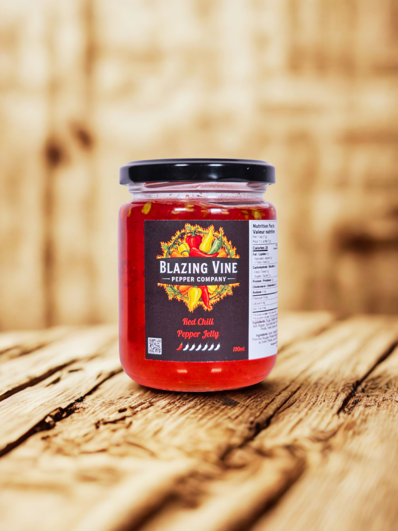 Blazing Vine Red Chili — vibrant red jelly in a glass jar on a rustic wood surface